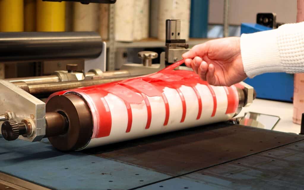 Port manchon adhésif avec cliché en préparation pour l'impression d'étiquettes sur presse flexo